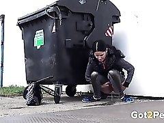 Shiny leggings girl pees behind a dumpster